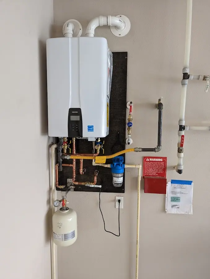 Professional plumber installing copper piping in a Iola home